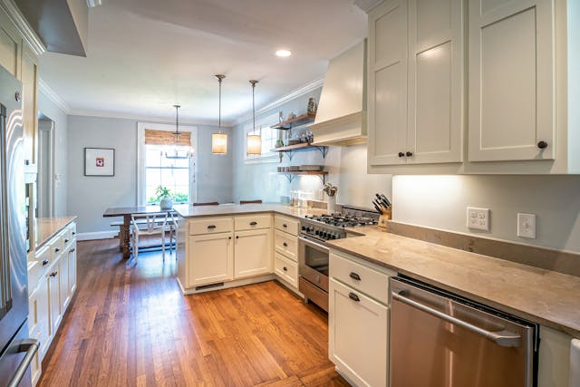 a blue kitchen with white cabinets and modern appliances